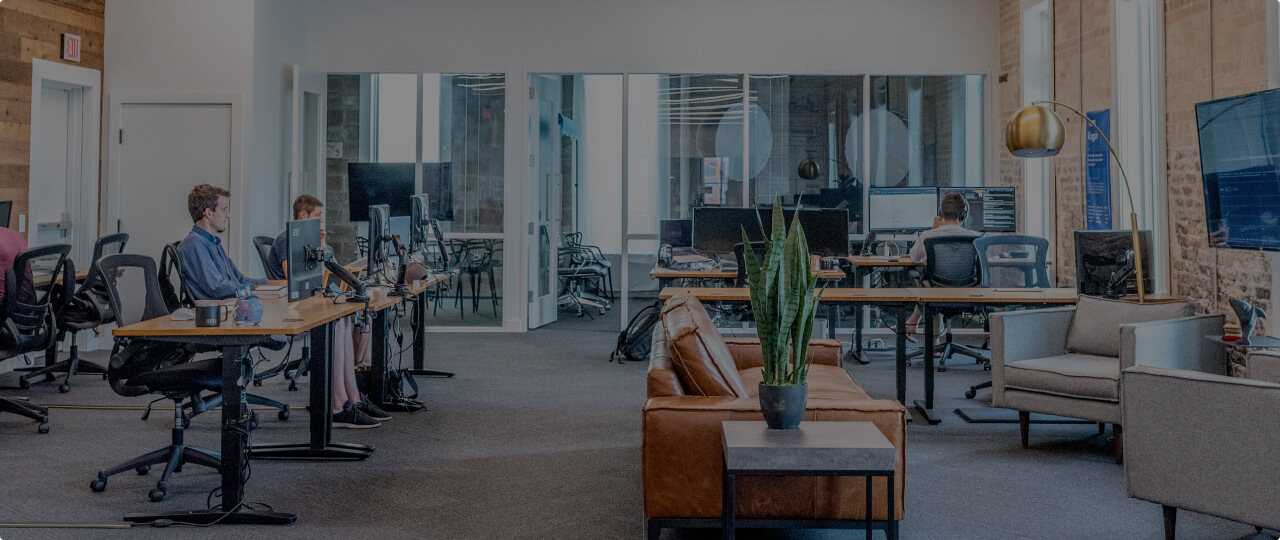 Employees are sitting at the computer in the office.